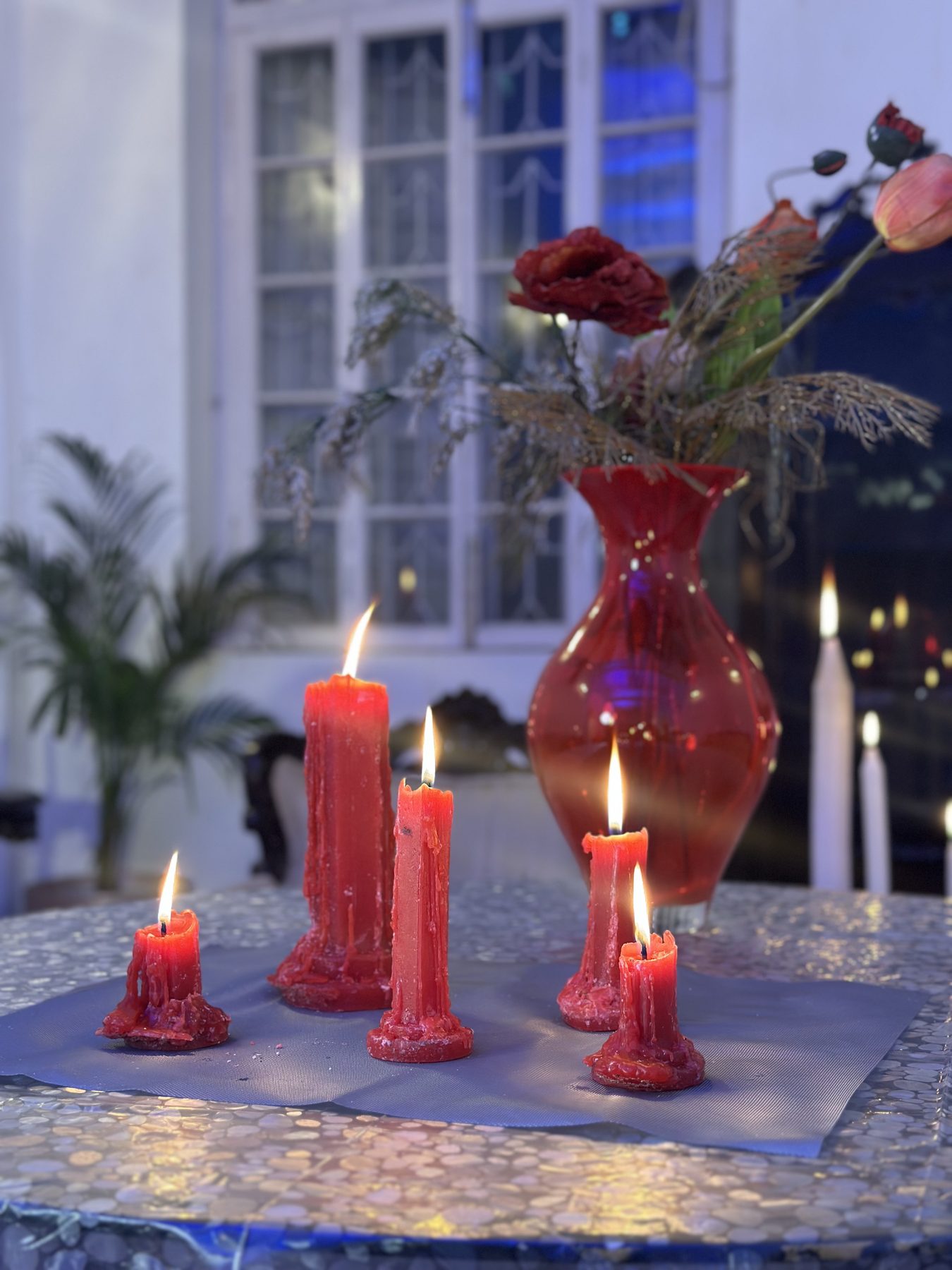 Red candles on a silver table in the FOI house