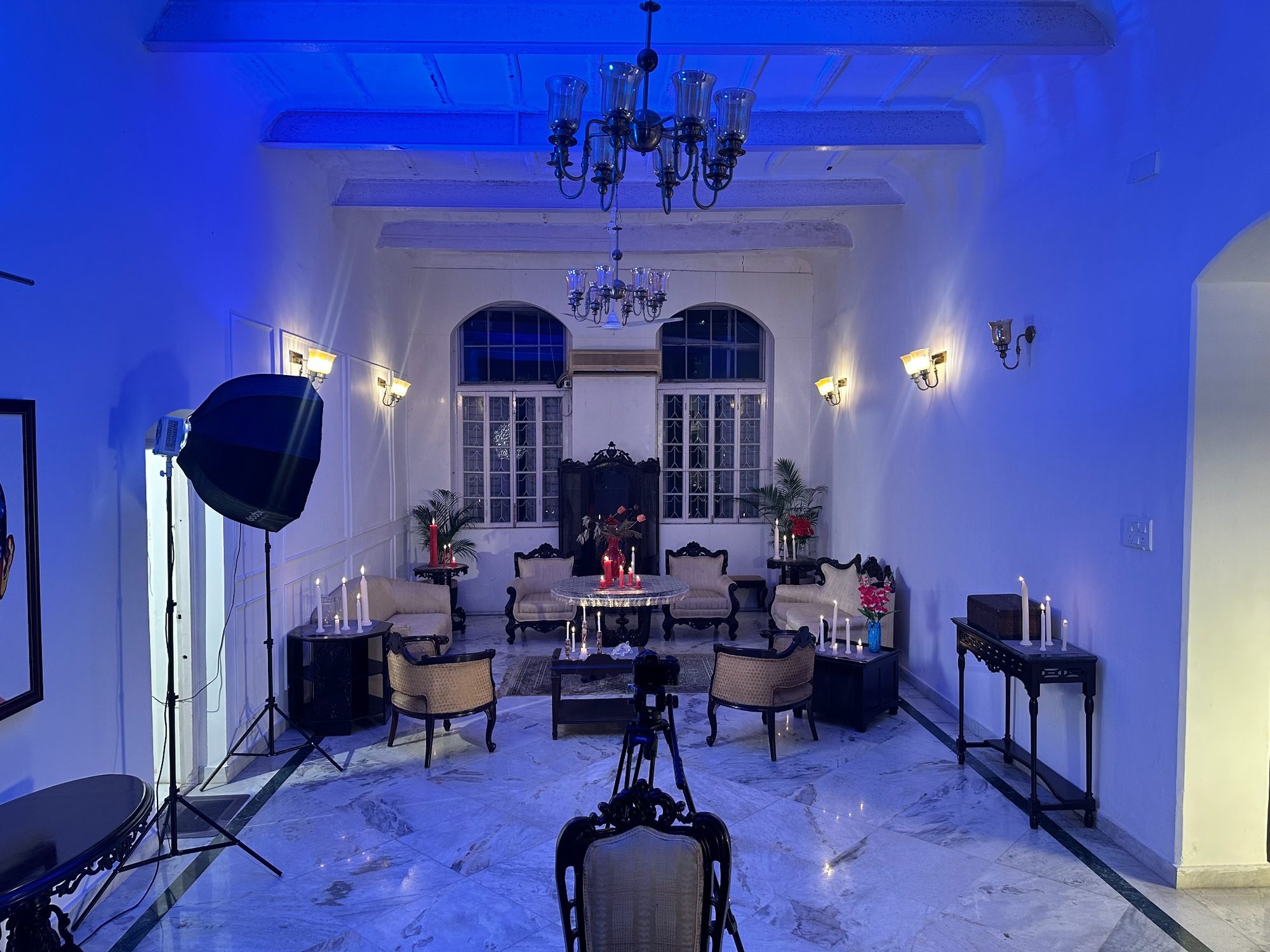 The FOI grand salon dressed for The Hundredth Chamber — candles, paintings, a camera on a stand