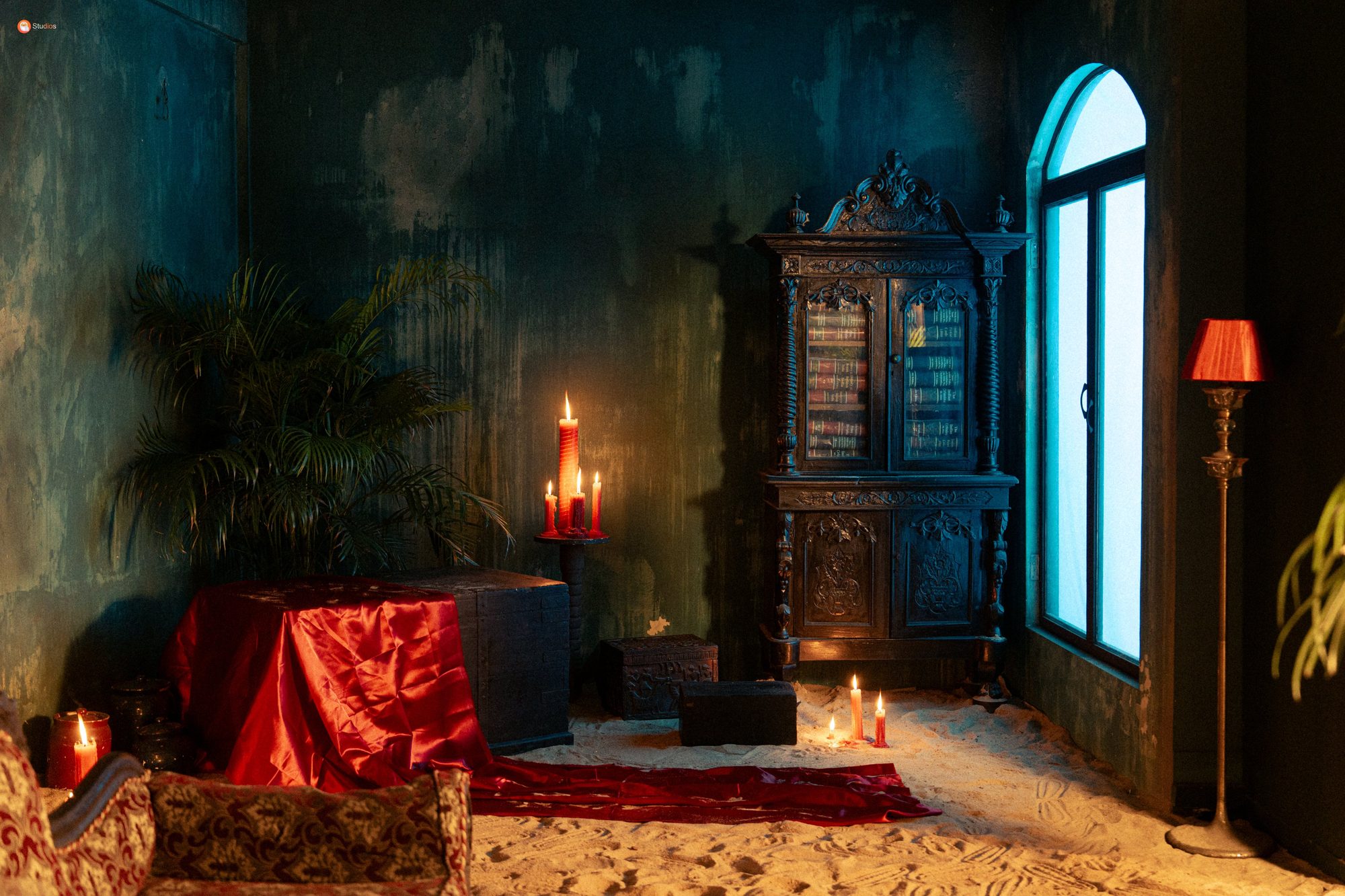Candlelit chamber with carved cabinet and red cloth